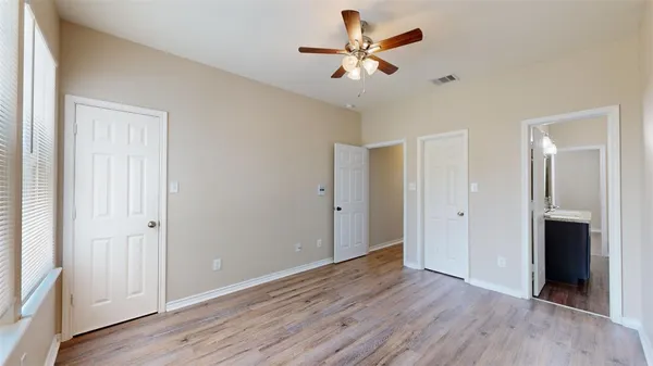 an empty room with wooden floor and windows