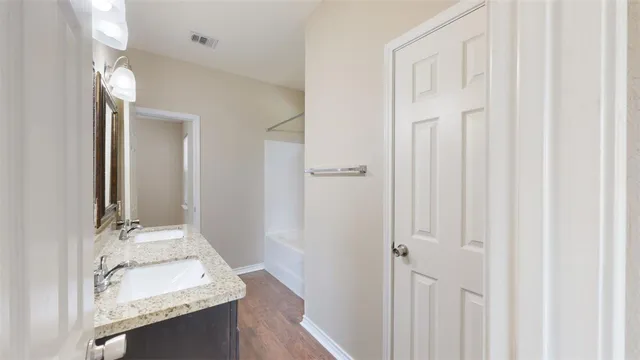 an empty room with wooden floor and ceiling fan