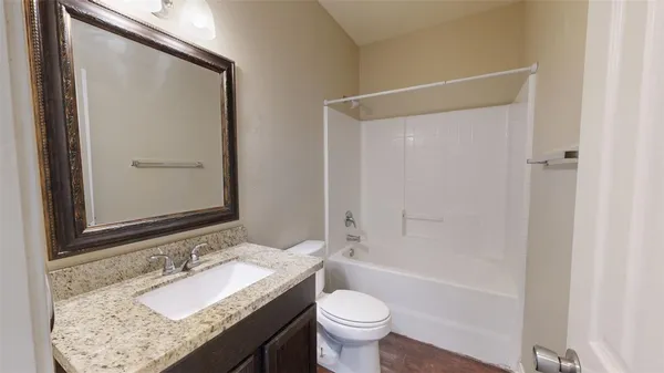 an empty room with wooden floor and ceiling fan