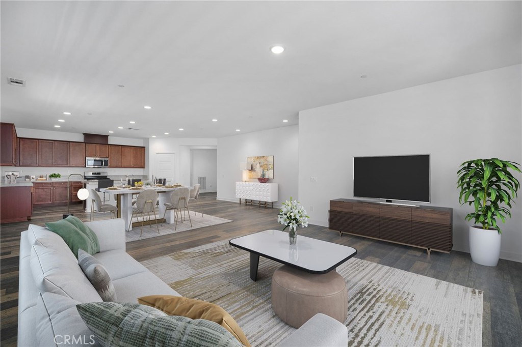 a living room with furniture kitchen view and a potted plant