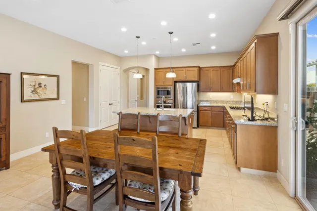 a kitchen with a sink a center island a table and chairs
