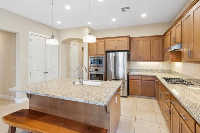 a kitchen with kitchen island granite countertop wooden cabinets a granite counter tops and a large window