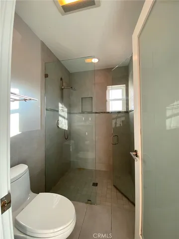 a bathroom with a toilet and a shower