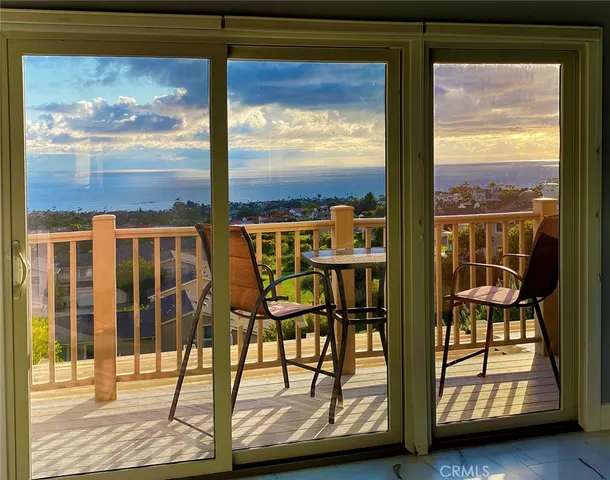 a view of a balcony with chairs and front door