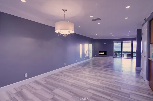 a view of empty room with wooden floor and window