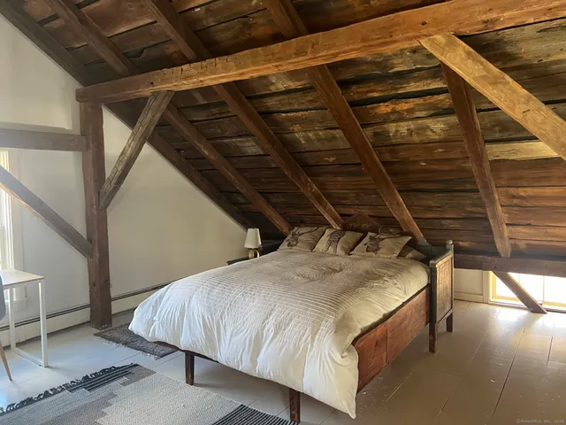 a bed sitting in a bedroom next to a window