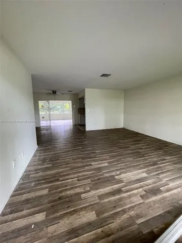 a view of empty room with window and wooden floor