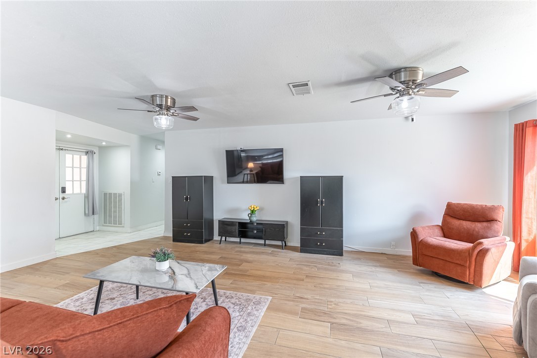 105 South Cimarron Road Las Vegas, NV 89145 - Photo 16 of 28 Smooth plaster walls and wood-look flooring establish a clean backdrop in this open living area.