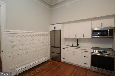 6314 Musgrave Street, Unit 4 Philadelphia, PA 19144 - Photo 5 of 10 a kitchen with a stove cabinets and a wooden floor