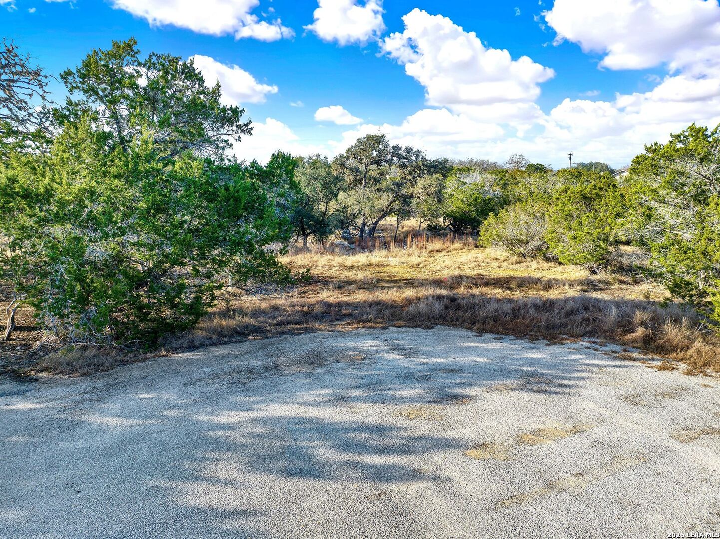 145 Elm Drive Bandera, TX 78003 - Photo 2 of 13 a view of dirt road with a building in the background