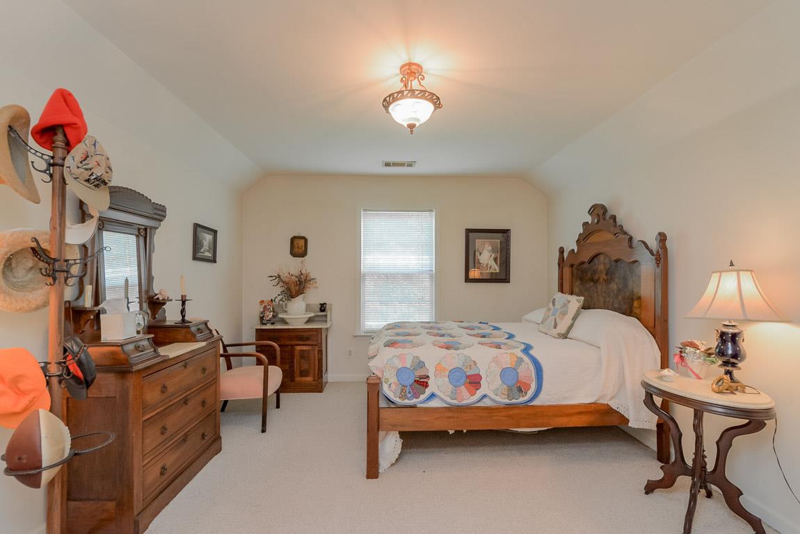 3387 Mahlon Moore Road Spring Hill, TN 37174 - Photo 24 of 29 a bedroom with bed and a chandelier