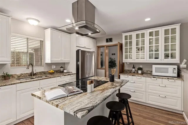 a kitchen with granite countertop a sink stainless steel appliances and window