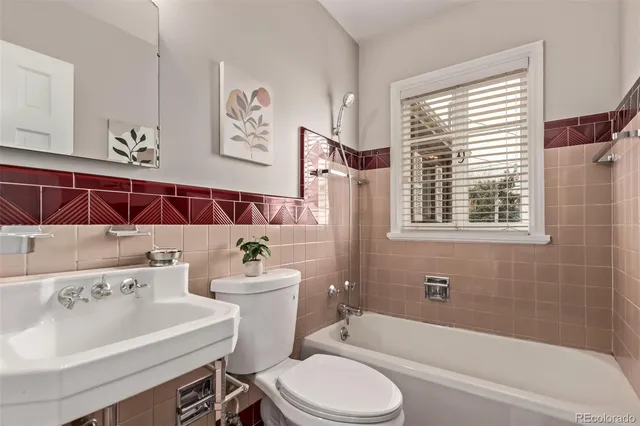 a bathroom with a bathtub sink vanity mirror and toilet