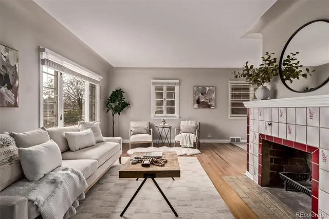 a living room with furniture a rug a fireplace and a large window