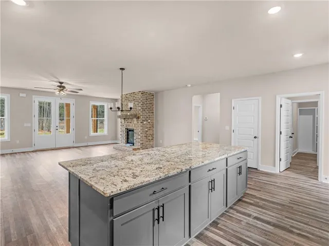 a bathroom with a granite countertop sink and a wooden floor