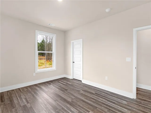 an empty room with wooden floor and a window