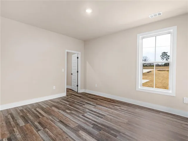 an empty room with wooden floor and a window