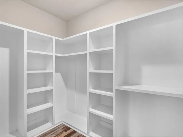 a view of walk in closet with empty racks