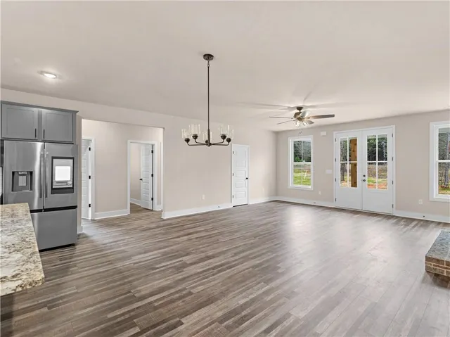 a view of an empty room with window and wooden floor