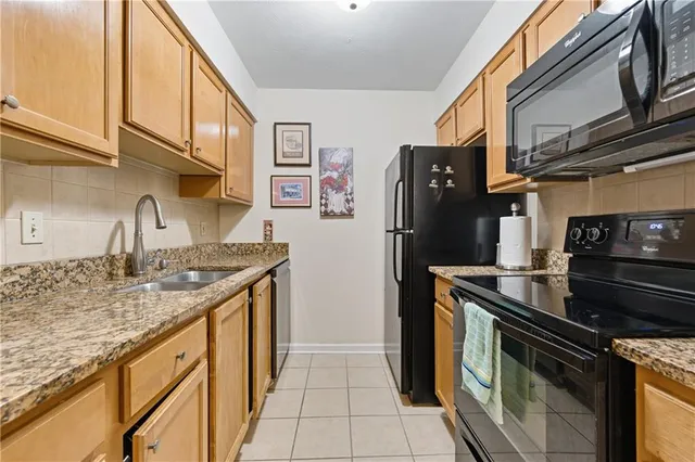 a kitchen with stainless steel appliances granite countertop a stove a refrigerator and a sink