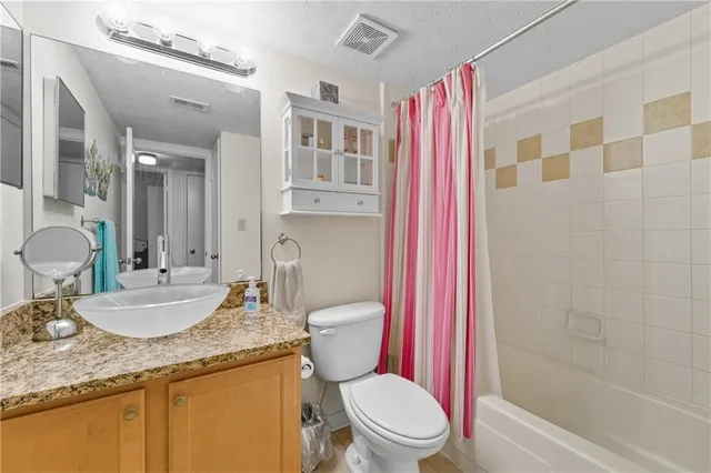 a bathroom with a granite countertop toilet sink and a shower