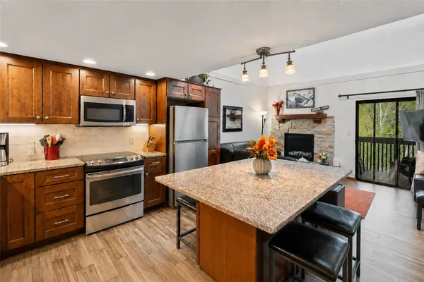 a kitchen with stainless steel appliances granite countertop a stove refrigerator sink and microwave