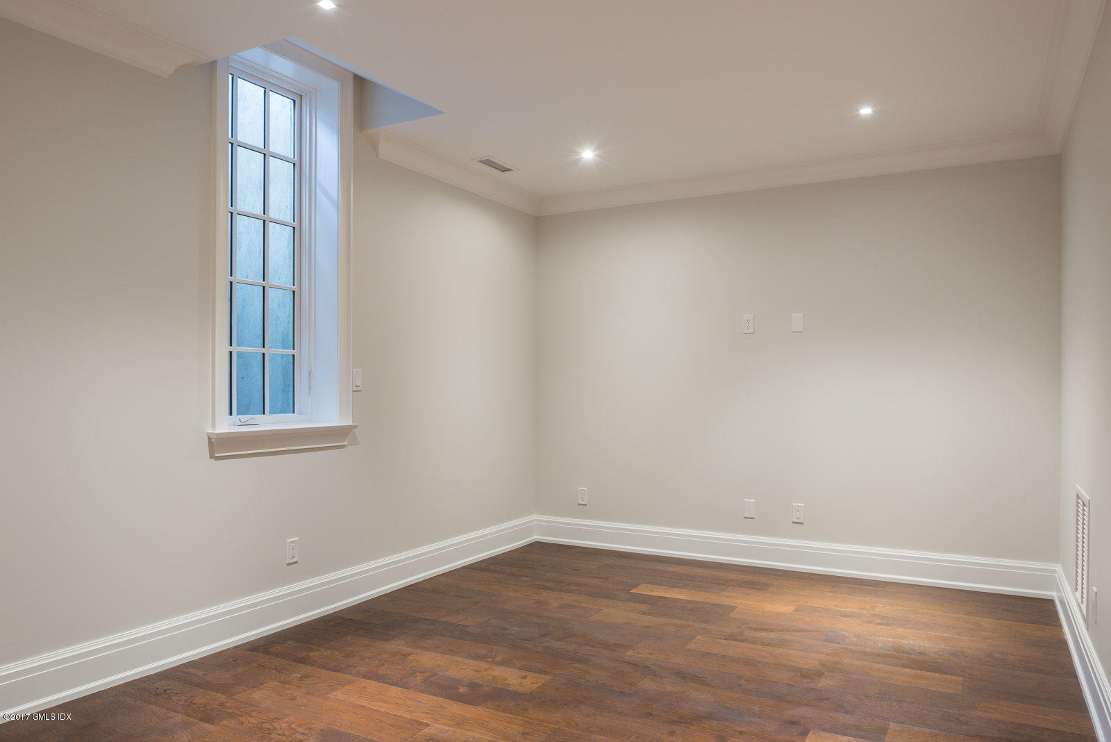 111 Mason Street, Unit 2A Greenwich, CT 06830 - Photo 16 of 18 a view of an empty room with wooden floor and a window