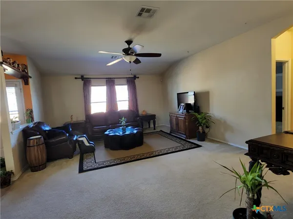 a living room with furniture a chandelier and a flat screen tv