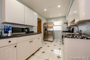 252-14 82nd Road Queens, NY 11426 - Photo 5 of 14 a kitchen with stainless steel appliances kitchen island granite countertop a sink a stove and cabinets