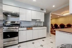 a kitchen with stainless steel appliances granite countertop a stove a sink and a microwave