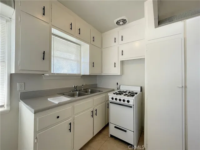 a kitchen with granite countertop a sink and cabinets