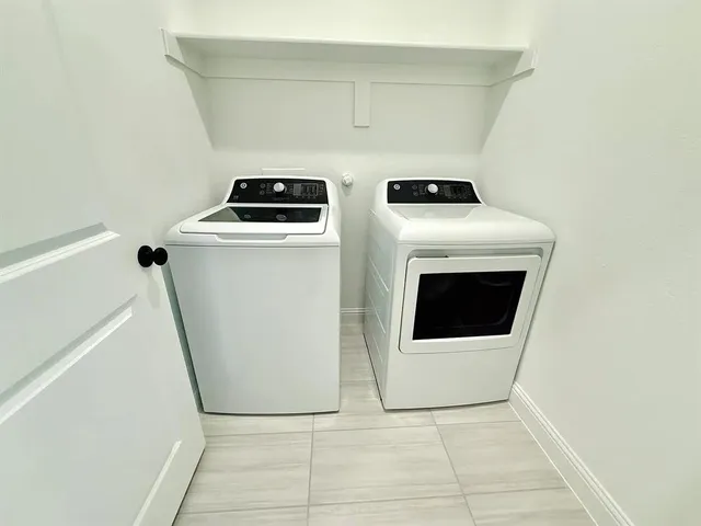 an empty room with chandelier fan and windows