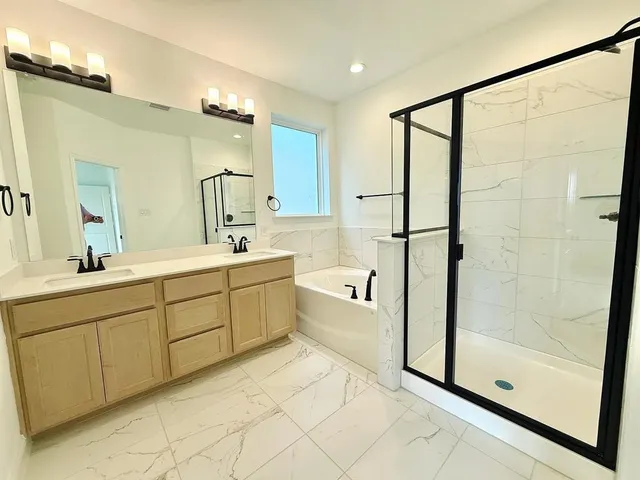 a bathroom with a tub sink and mirror