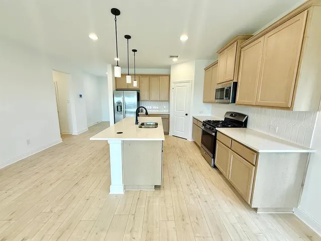 a large white kitchen with wooden floor
