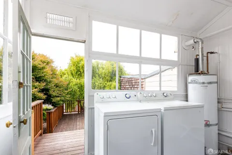 a utility room with dryer washer and a view of living room