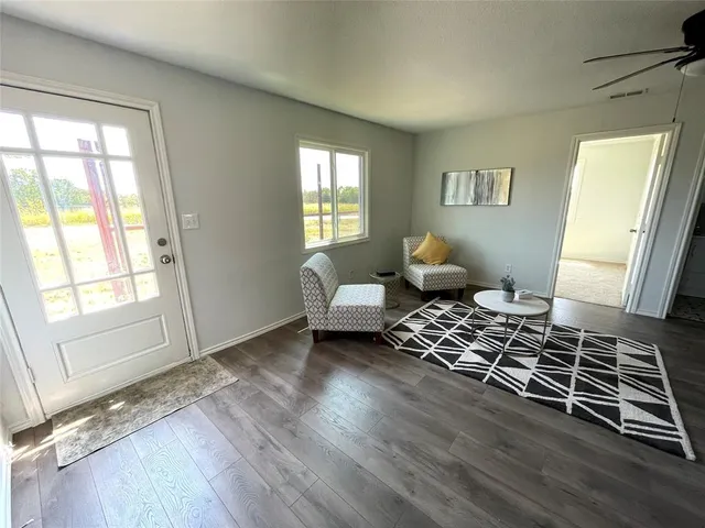 a living room with furniture and wooden floor