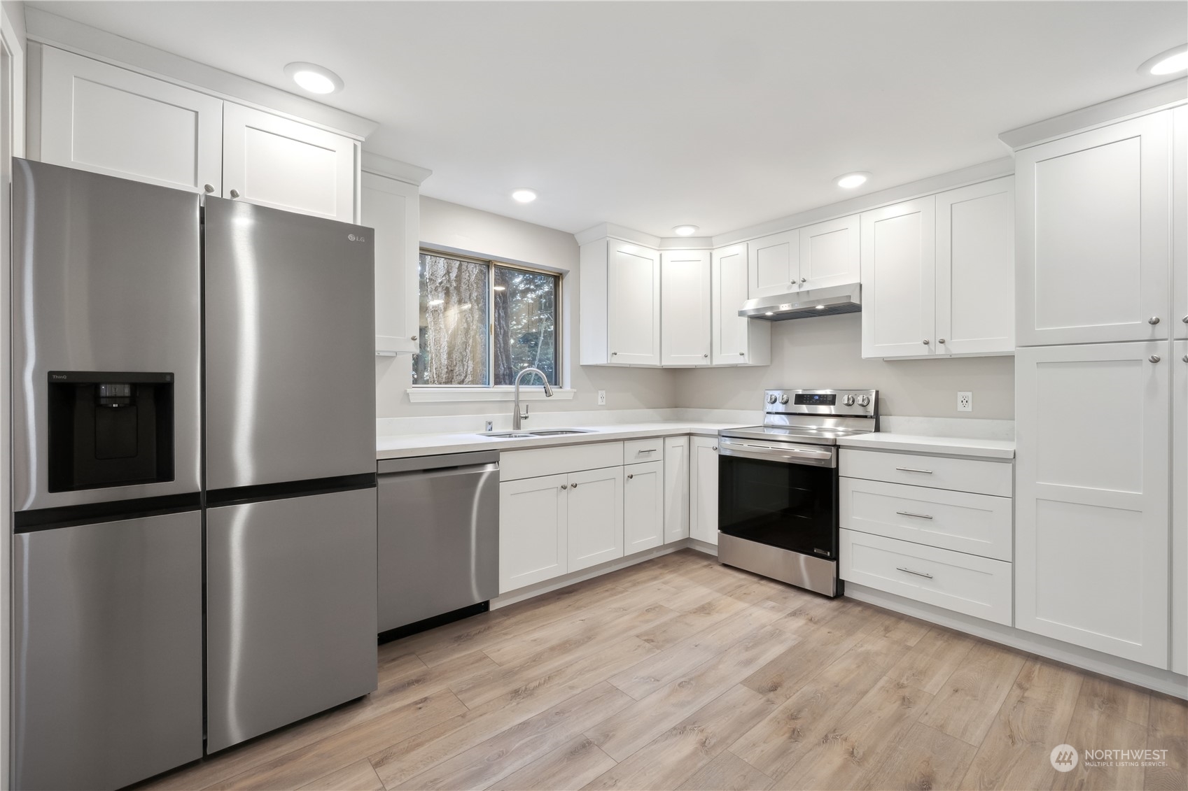 2130 242nd Street Southwest Bothell, WA 98021 - Photo 14 of 40 a kitchen with a refrigerator and white cabinets