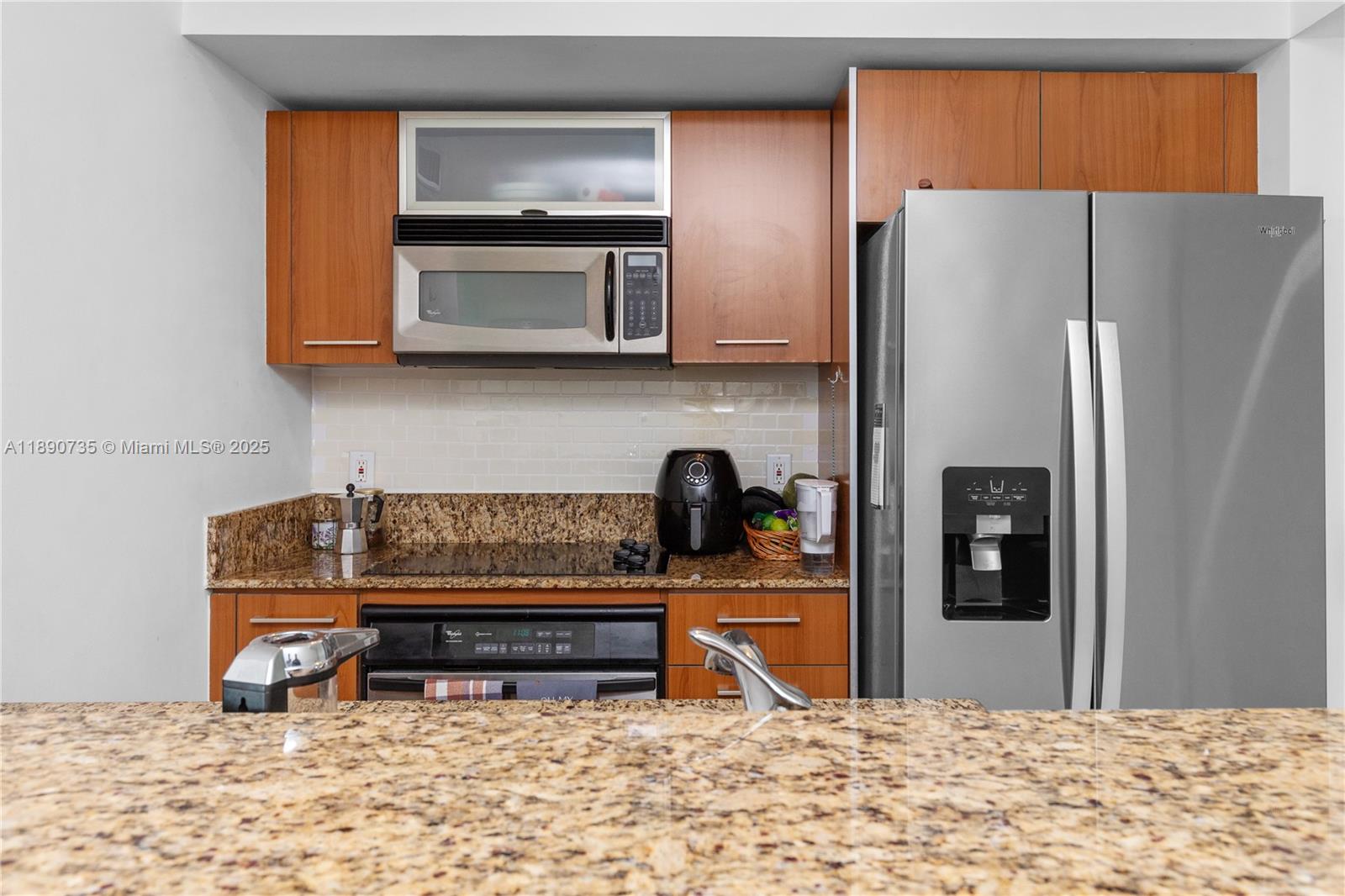 9055 Southwest 73rd Court, Unit 1603 Miami, FL 33156 - Photo 12 of 28 a kitchen with stainless steel appliances granite countertop a refrigerator and a stove top oven