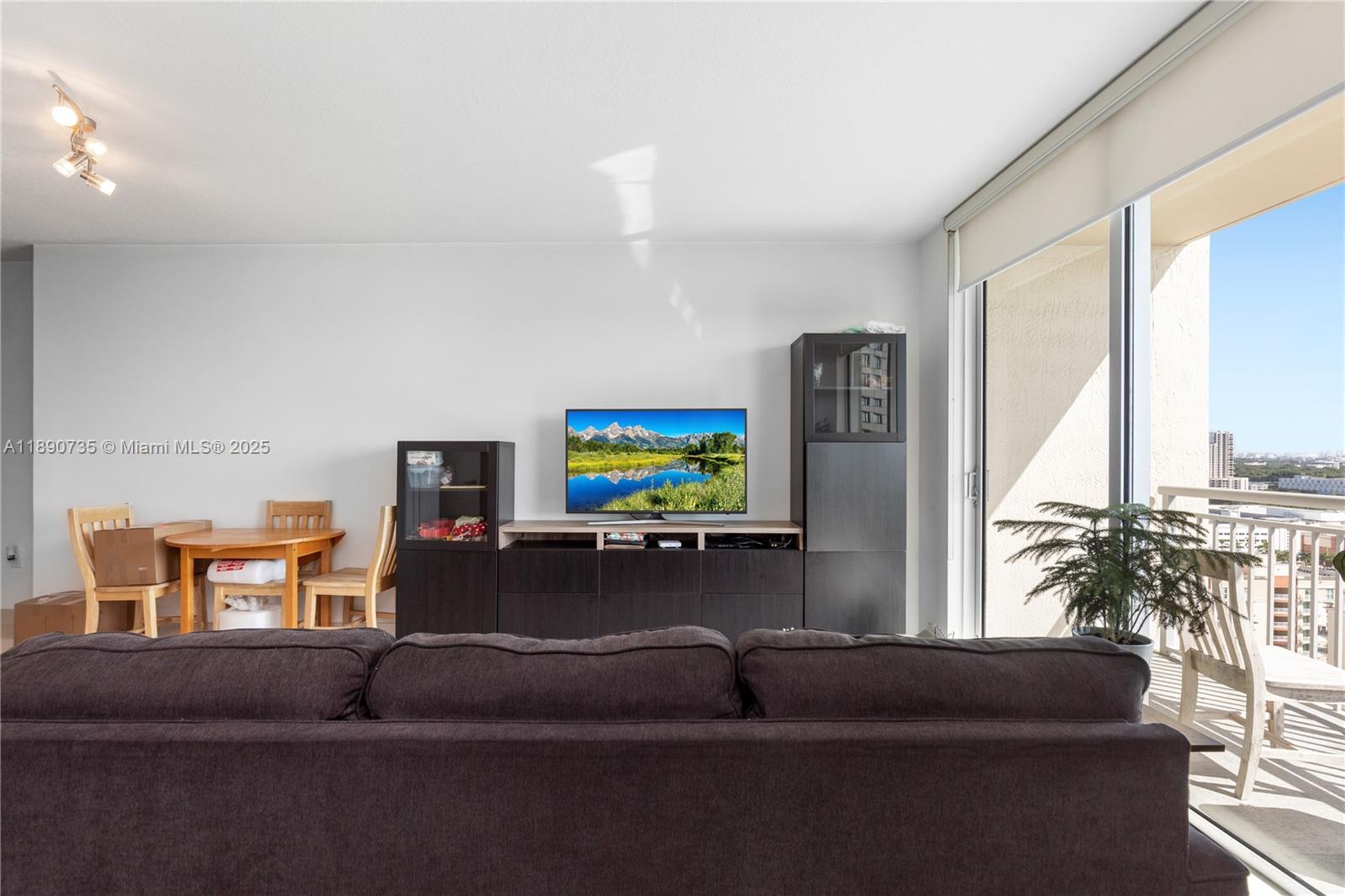 9055 Southwest 73rd Court, Unit 1603 Miami, FL 33156 - Photo 3 of 28 a living room with furniture and a flat screen tv