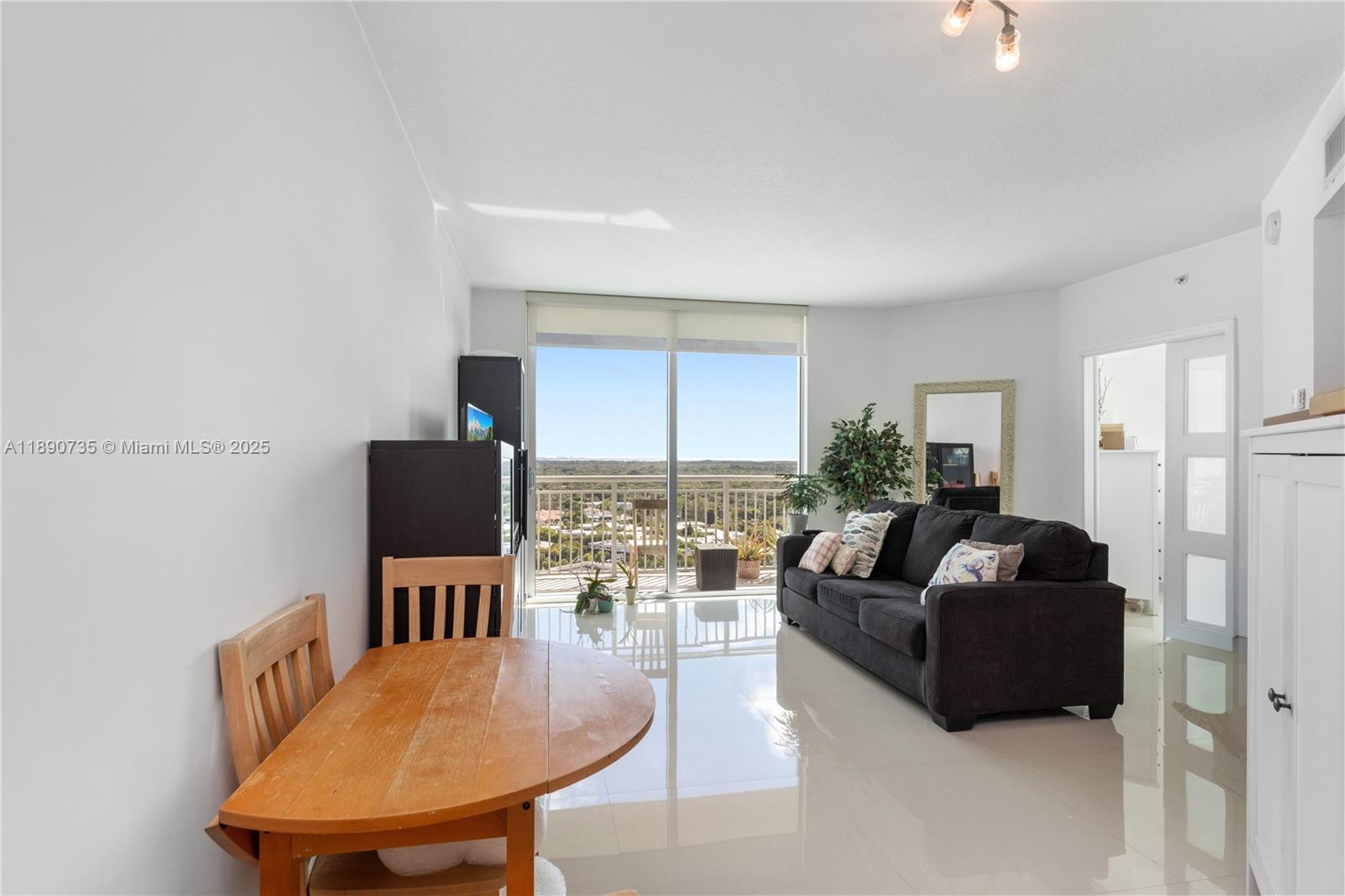 9055 Southwest 73rd Court, Unit 1603 Miami, FL 33156 - Photo 4 of 28 a living room with furniture a table and a flat screen tv