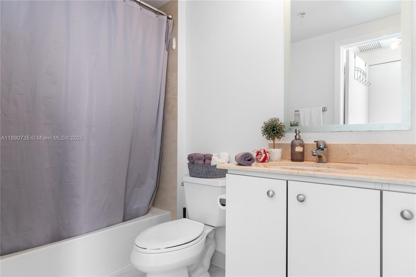 9055 Southwest 73rd Court, Unit 1603 Miami, FL 33156 - Photo 7 of 28 a bathroom with a sink a toilet and a mirror
