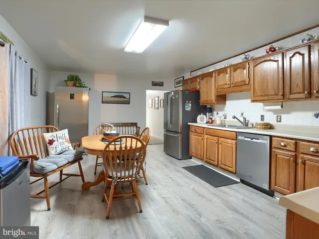 a kitchen with stainless steel appliances granite countertop a kitchen island hardwood floor and a sink