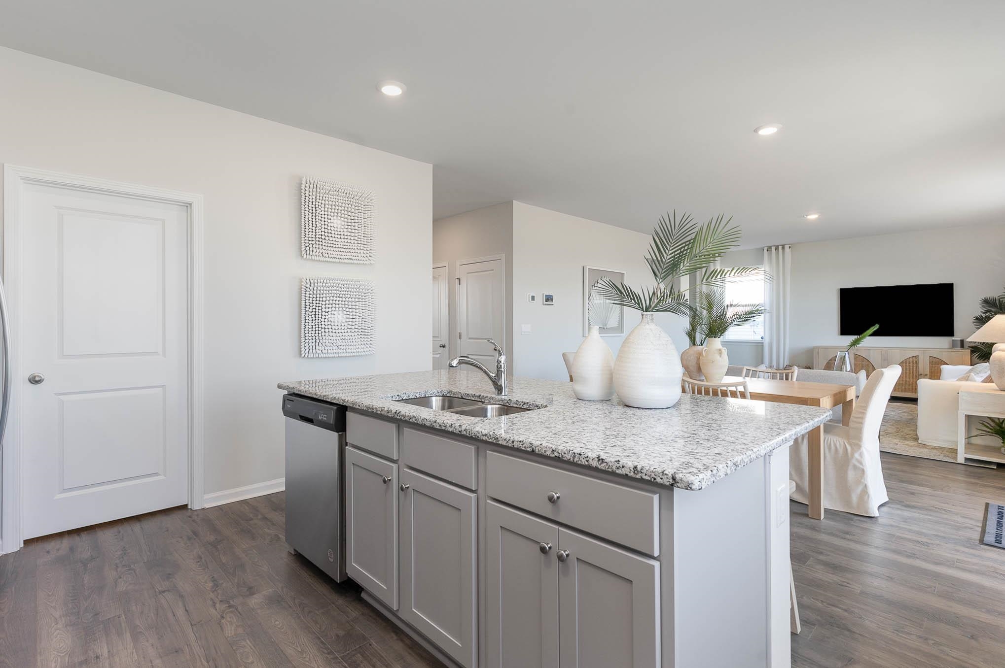 1328 Parkside Court Conway, SC 29527 - Photo 10 of 28 Kitchen with gray cabinetry, light stone counters, a kitchen island with sink, stainless steel dishwasher, and dark wood-style flooring