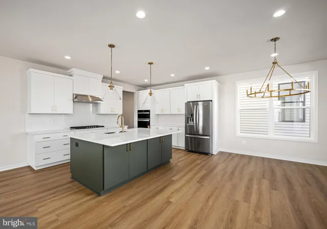 a kitchen with stainless steel appliances granite countertop a sink a stove and a refrigerator