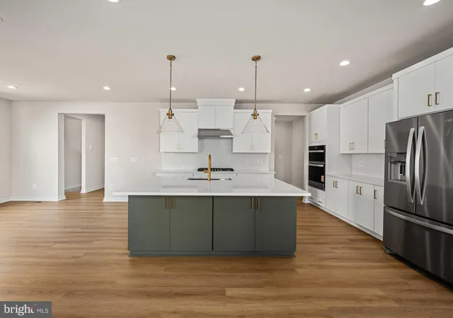 a kitchen with a sink stove and wooden floor