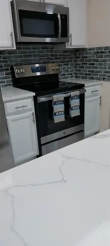 a stove top oven sitting inside of a kitchen