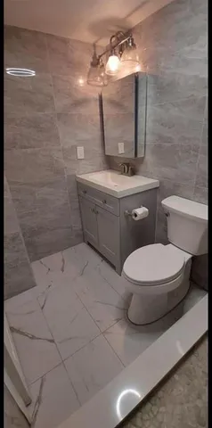 a bathroom with a toilet sink and mirror