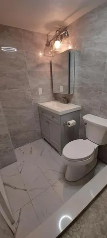 a bathroom with a toilet sink and mirror