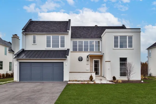 a front view of a house with a yard and garage