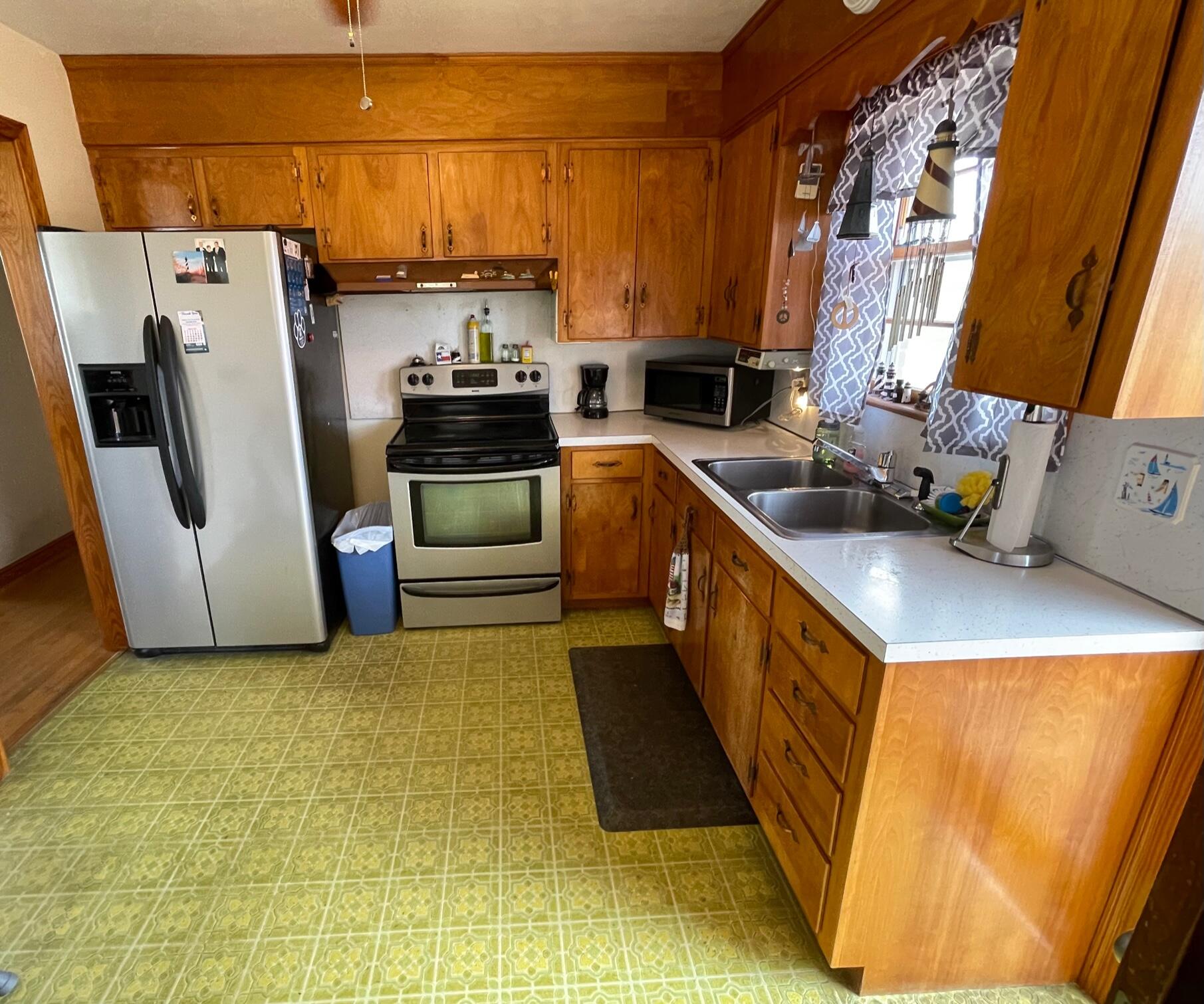 516 Mapleton Avenue Northeast Roanoke, VA 24012 - Photo 14 of 21 a kitchen with a sink a stove and a refrigerator